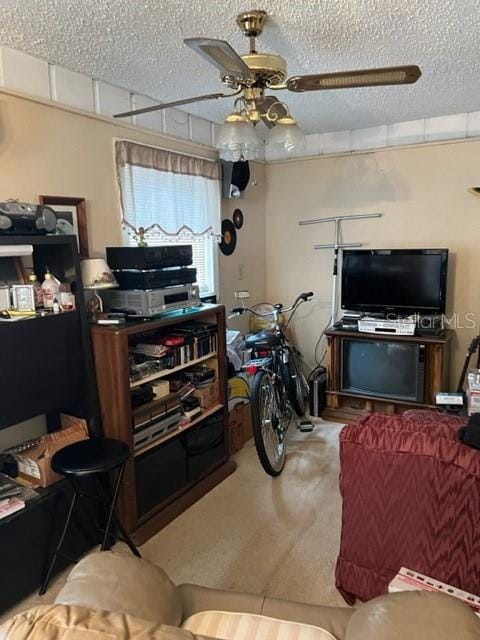 living room with a textured ceiling, carpet, and ceiling fan