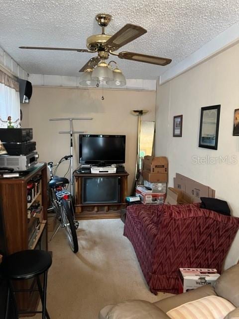 carpeted living room with a textured ceiling and ceiling fan