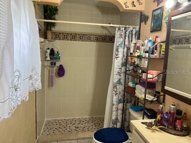 bathroom with curtained shower, toilet, and vanity