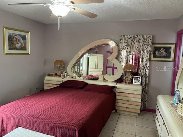 bedroom with light tile flooring, ceiling fan, and a textured ceiling