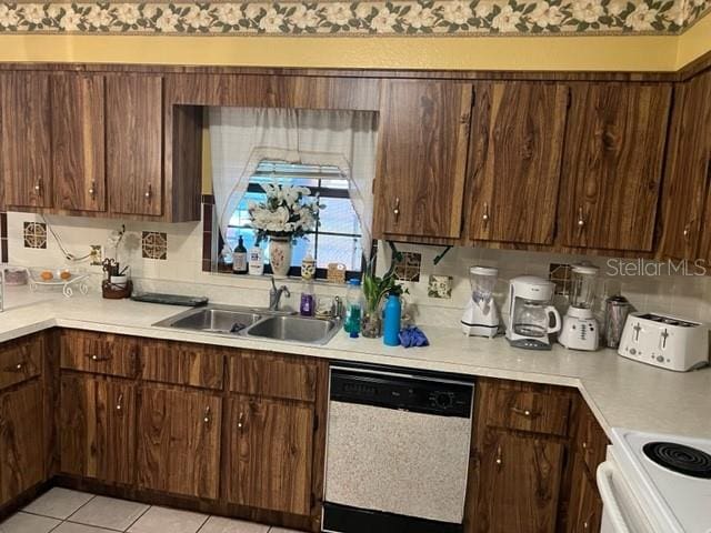 kitchen featuring white dishwasher, tasteful backsplash, dark brown cabinets, and sink