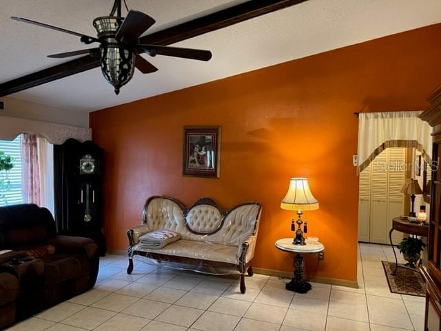 tiled living room with beam ceiling and ceiling fan