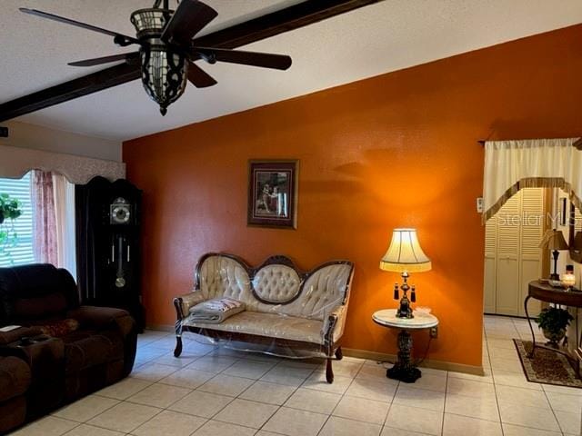 tiled living room featuring ceiling fan and beamed ceiling