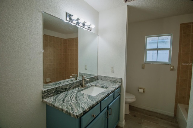 full bathroom with toilet, tiled shower / bath, tile flooring, a textured ceiling, and vanity