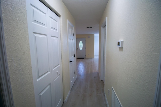 hallway with light hardwood / wood-style flooring