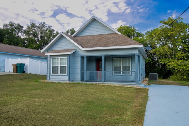 view of front of home with covered porch, central air condition unit, and a front lawn