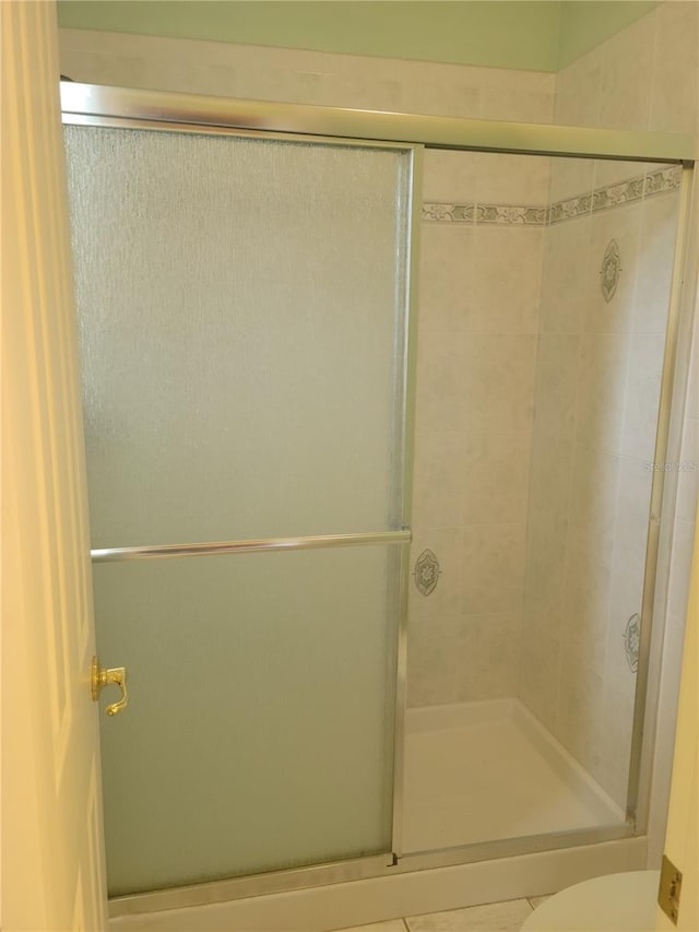 bathroom with an enclosed shower and toilet