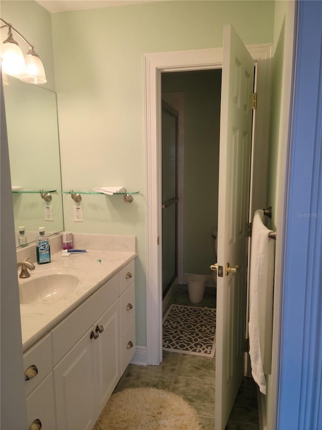 bathroom with tile flooring, walk in shower, and vanity