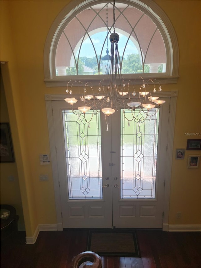 entrance foyer with a wealth of natural light, french doors, and an inviting chandelier