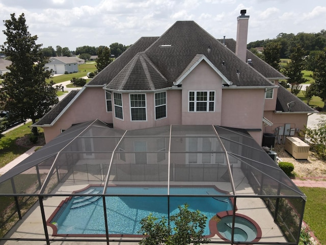 view of swimming pool featuring an in ground hot tub and a lanai