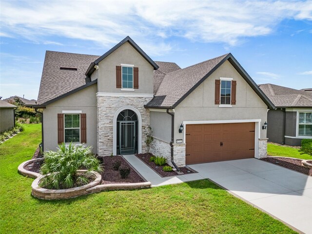 view of front of property with a front yard and a garage