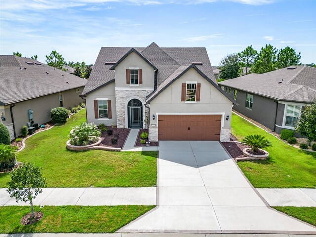 view of front of home with a front yard and a garage