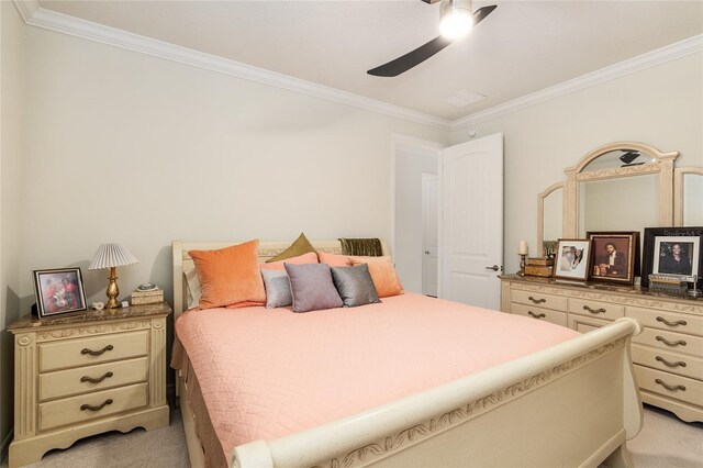 carpeted bedroom with ornamental molding and ceiling fan