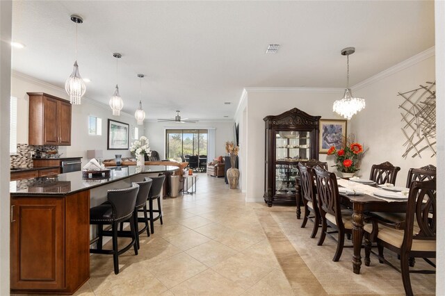 tiled dining room with crown molding and ceiling fan with notable chandelier