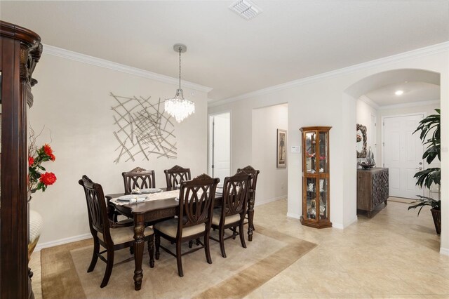 dining room with an inviting chandelier, light tile floors, and ornamental molding