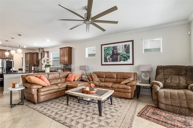 tiled living room with ornamental molding and ceiling fan