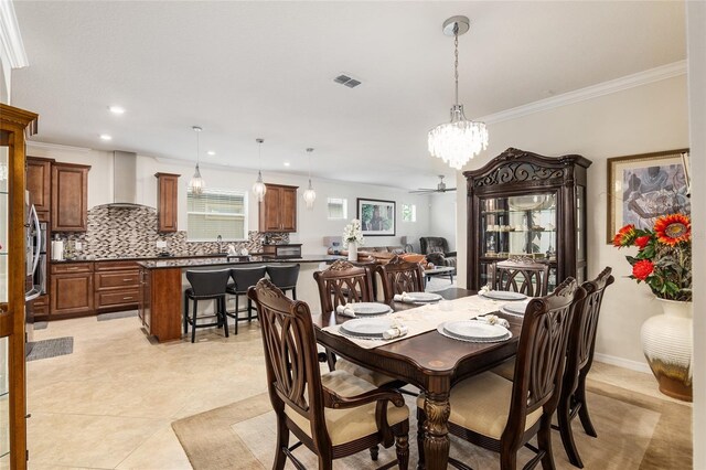 tiled dining space with crown molding and ceiling fan with notable chandelier