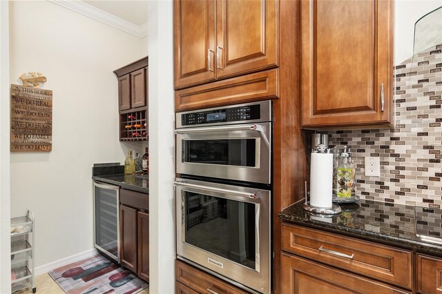 kitchen with dark stone counters, beverage cooler, crown molding, stainless steel double oven, and backsplash