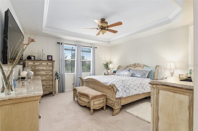 bedroom featuring light carpet, a tray ceiling, and ceiling fan