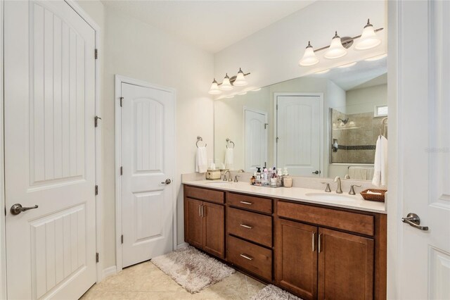 bathroom with double vanity, a tile shower, and tile floors