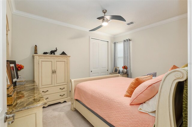 bedroom featuring a closet, crown molding, ceiling fan, and light colored carpet