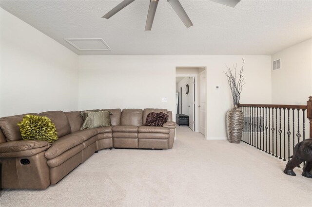 living room featuring light carpet, a textured ceiling, and ceiling fan