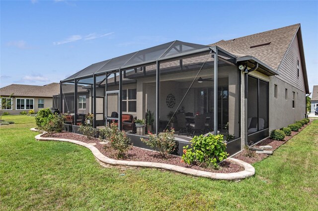 back of house with glass enclosure and a lawn