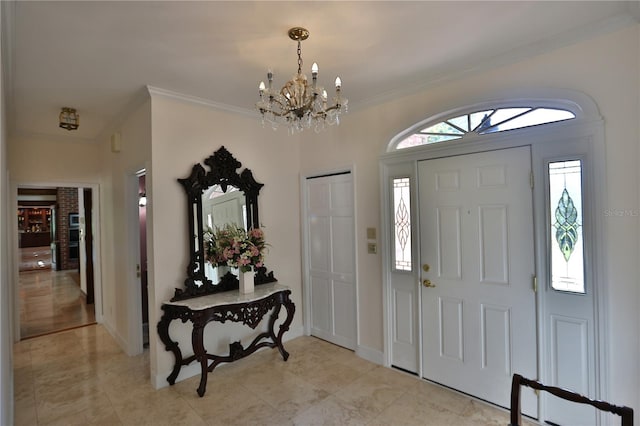 foyer with an inviting chandelier, ornamental molding, and light tile flooring