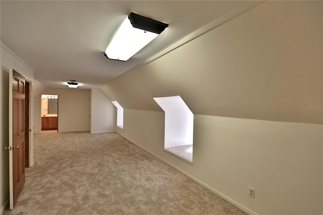 bonus room with light carpet and vaulted ceiling