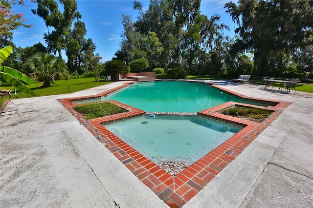 view of pool with an in ground hot tub, a yard, and a patio area