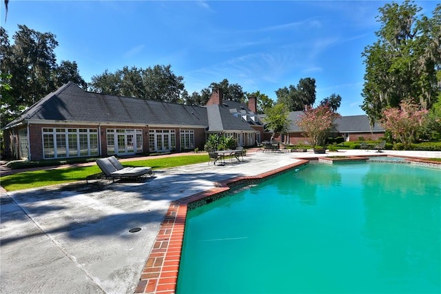 view of swimming pool featuring a yard and a patio area