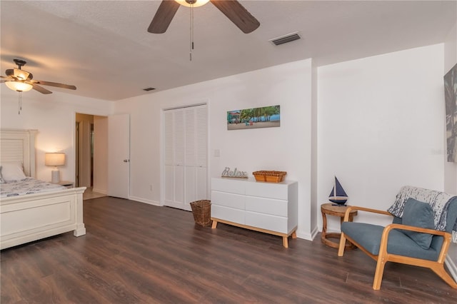 bedroom with dark wood-type flooring, a closet, and ceiling fan