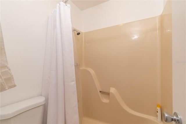 bathroom featuring shower / bath combo and toilet