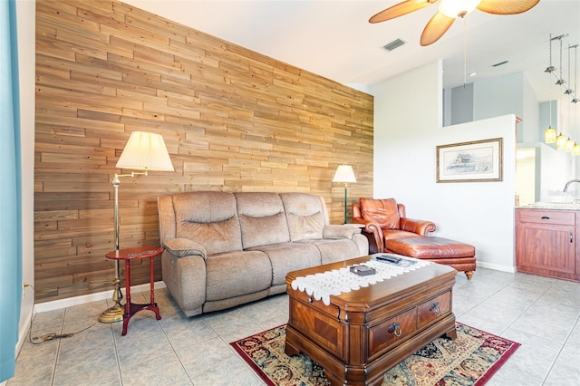 tiled living room with wooden walls and ceiling fan