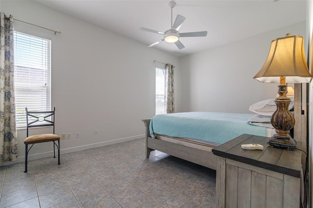 tiled bedroom featuring multiple windows and ceiling fan