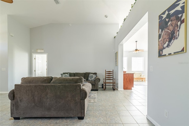 tiled living room with ceiling fan and high vaulted ceiling