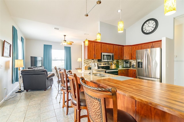 kitchen with ceiling fan, sink, appliances with stainless steel finishes, tasteful backsplash, and decorative light fixtures