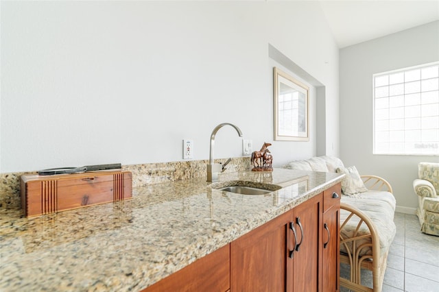 bathroom with tile floors, a healthy amount of sunlight, lofted ceiling, and sink