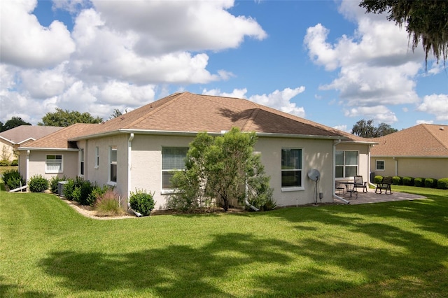 rear view of property featuring a lawn and a patio