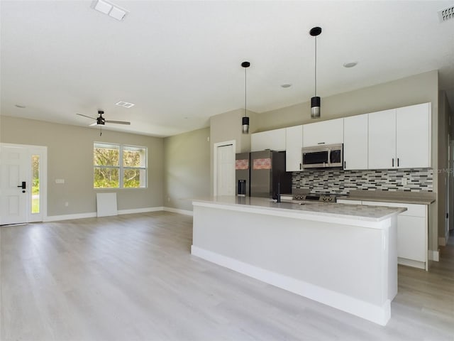 kitchen featuring fridge with ice dispenser, ceiling fan, decorative light fixtures, and white cabinetry