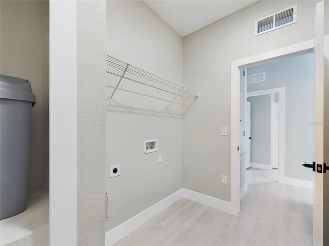 clothes washing area with hookup for a washing machine, electric dryer hookup, and light wood-type flooring