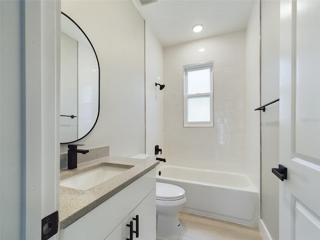 full bathroom with hardwood / wood-style flooring, toilet, tiled shower / bath combo, and vanity