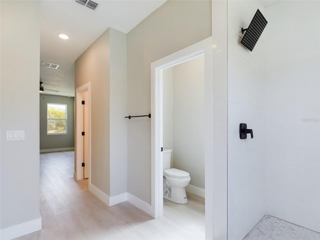 bathroom featuring toilet, wood-type flooring, and ceiling fan