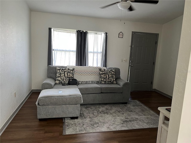 living room featuring ceiling fan and dark wood-type flooring