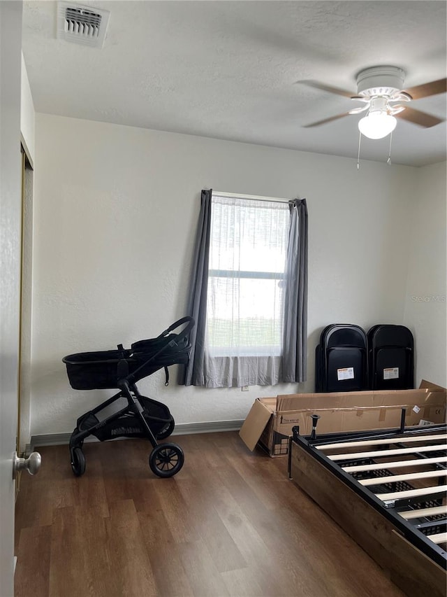 bedroom with ceiling fan and dark hardwood / wood-style flooring