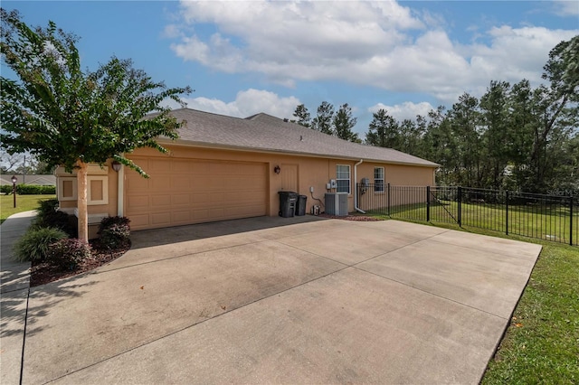 view of side of home featuring a yard, a garage, and central air condition unit