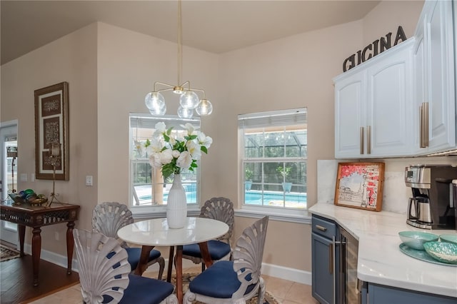 dining room featuring a healthy amount of sunlight, light hardwood / wood-style floors, and an inviting chandelier