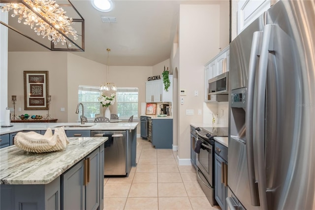 kitchen featuring white cabinets, a kitchen island, sink, and stainless steel appliances