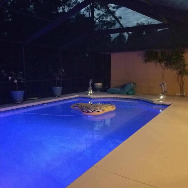 view of swimming pool featuring a lanai