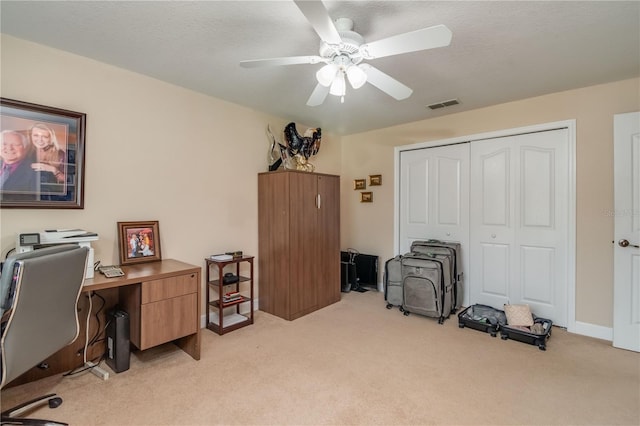 carpeted home office featuring ceiling fan and a textured ceiling